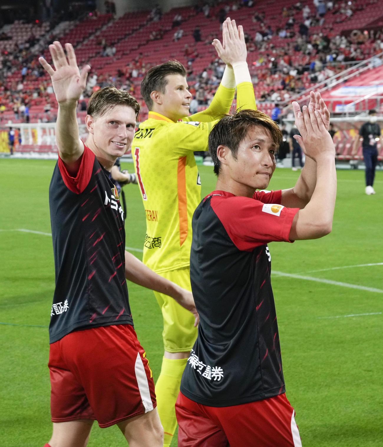 川崎Fに勝利し歓声に応える、名古屋の選手ら。左からユンカー、GKランゲラック、和泉（共同）
