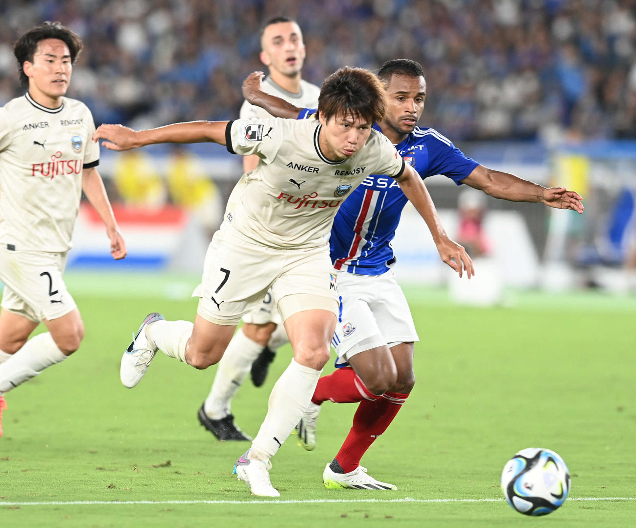 横浜対川崎F　後半、川崎F車屋（中央）は横浜エウベルのドリブルを止める。左は登里（撮影・山崎安昭）