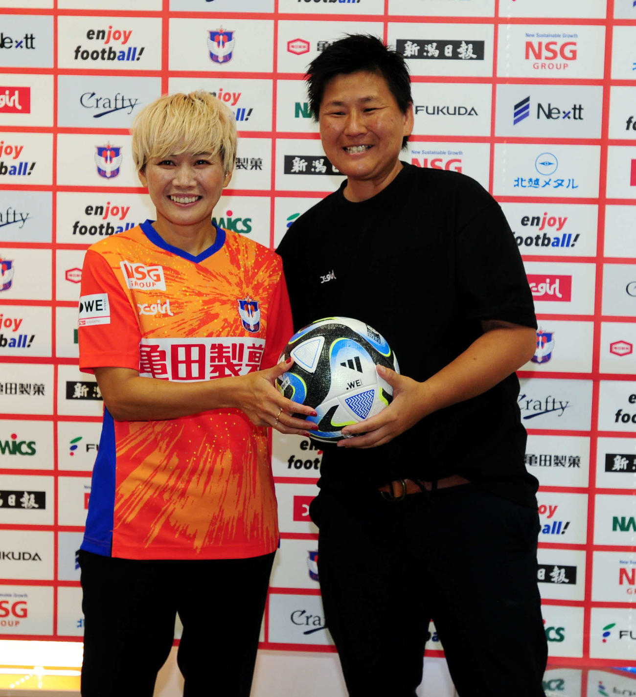 会見に訪れていた元日本女子代表のGK海堀（右）と笑顔で写真を撮る新潟レディース・川澄