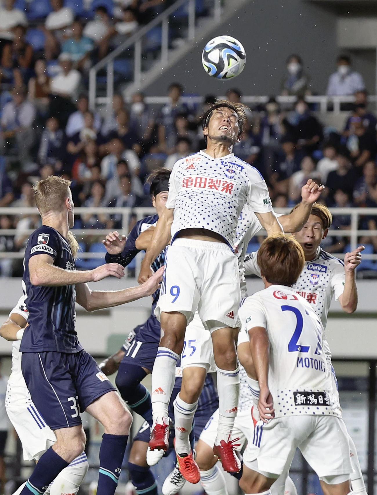 後半、ボールをクリアする新潟・鈴木（中央）（共同）