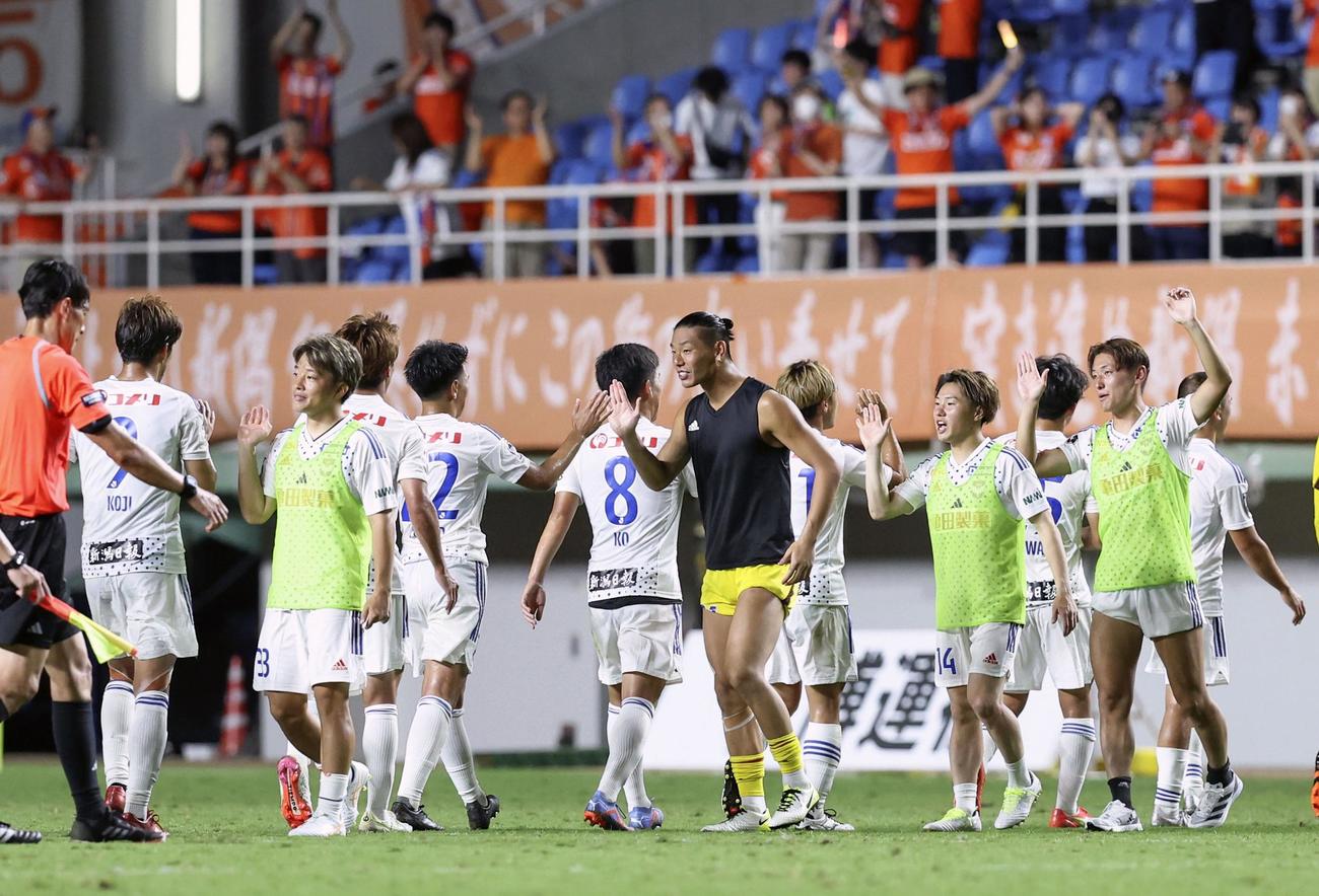 福岡に勝利し、タッチを交わす新潟イレブン（共同）