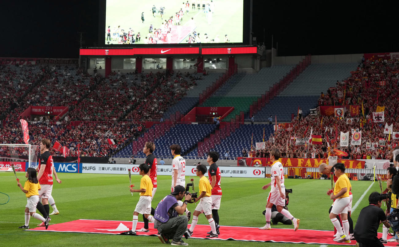 浦和対名古屋　緩衝帯を大幅に取った中で入場する両チームの選手たち（撮影・狩俣裕三）