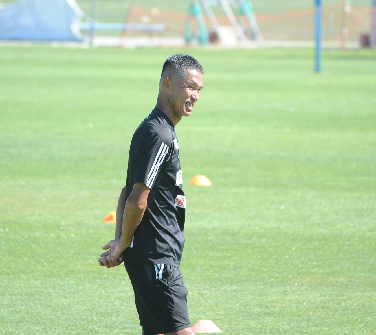 鹿島戦の前日練習前にスタッフと雑談する松橋監督
