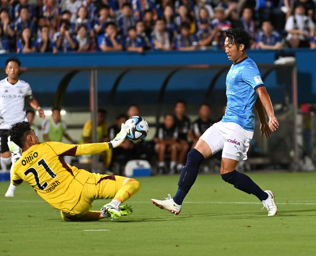 横浜FC対横浜　前半、横浜FC伊藤（右）が放ったシュートは横浜GK飯倉がセーブ（撮影・山崎安昭）
