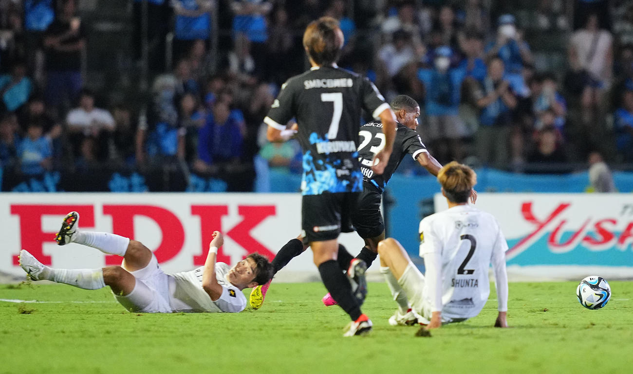 川崎F対札幌　後半、川崎Fマルシーニョ（中央）にスライディングでタックルするもかわされる札幌岡村（左）（撮影・垰建太）