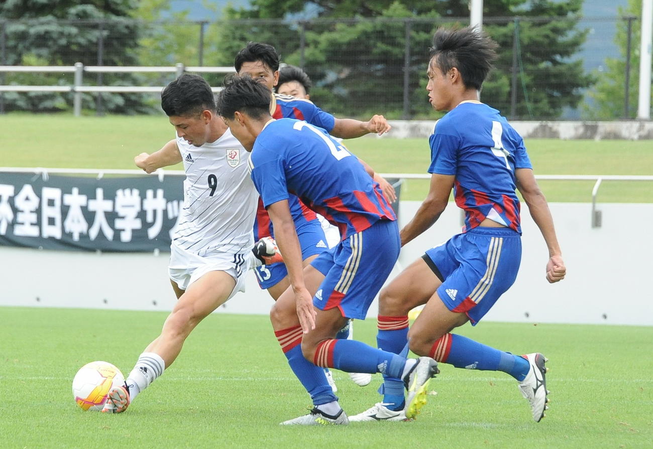 相手3人に囲まれながらもシュートを放つ田中（左）