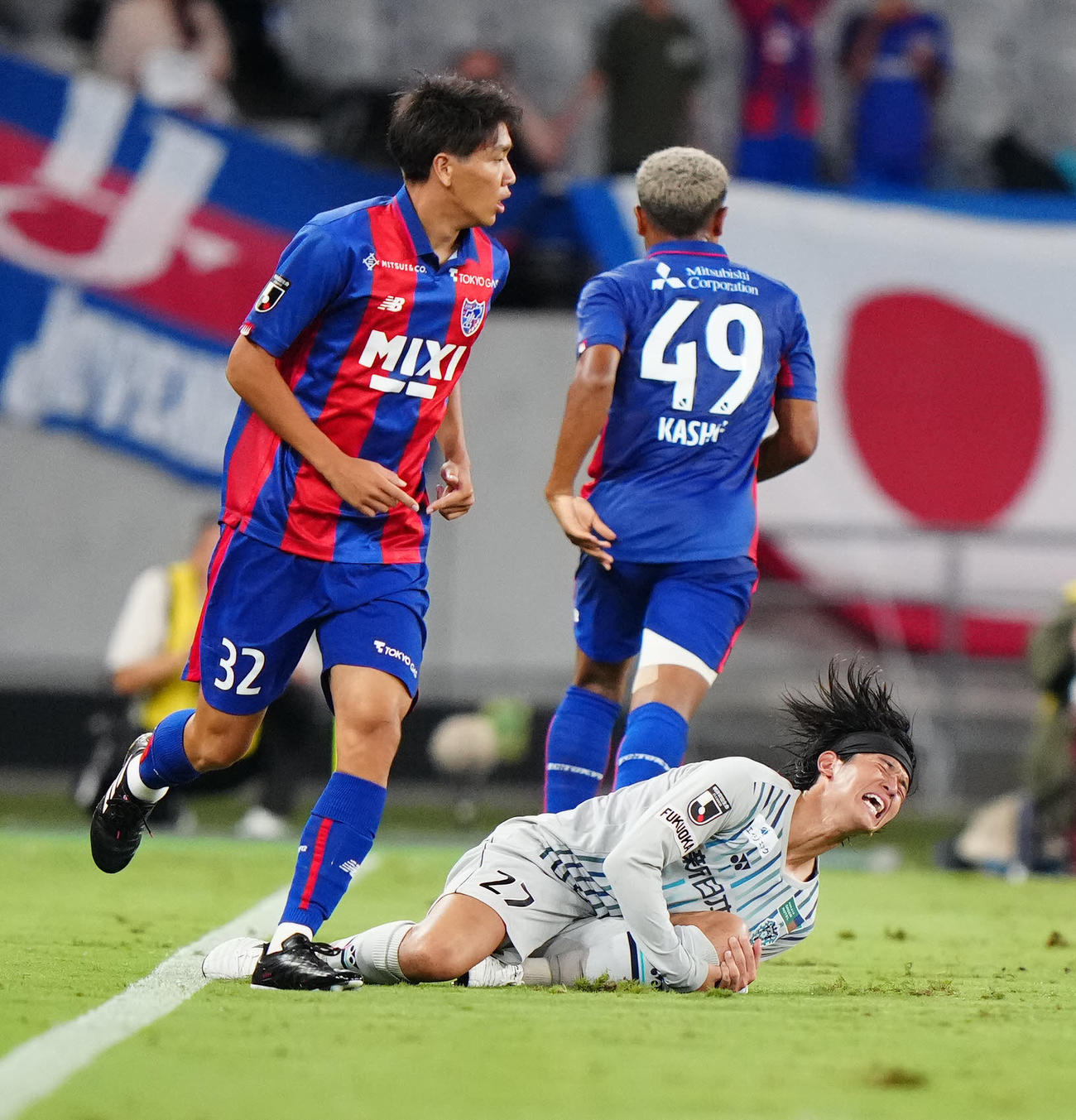 東京対福岡　後半、右膝付近を手で押さえ、厳しい表情の福岡佐藤（右下）（撮影・江口和貴）