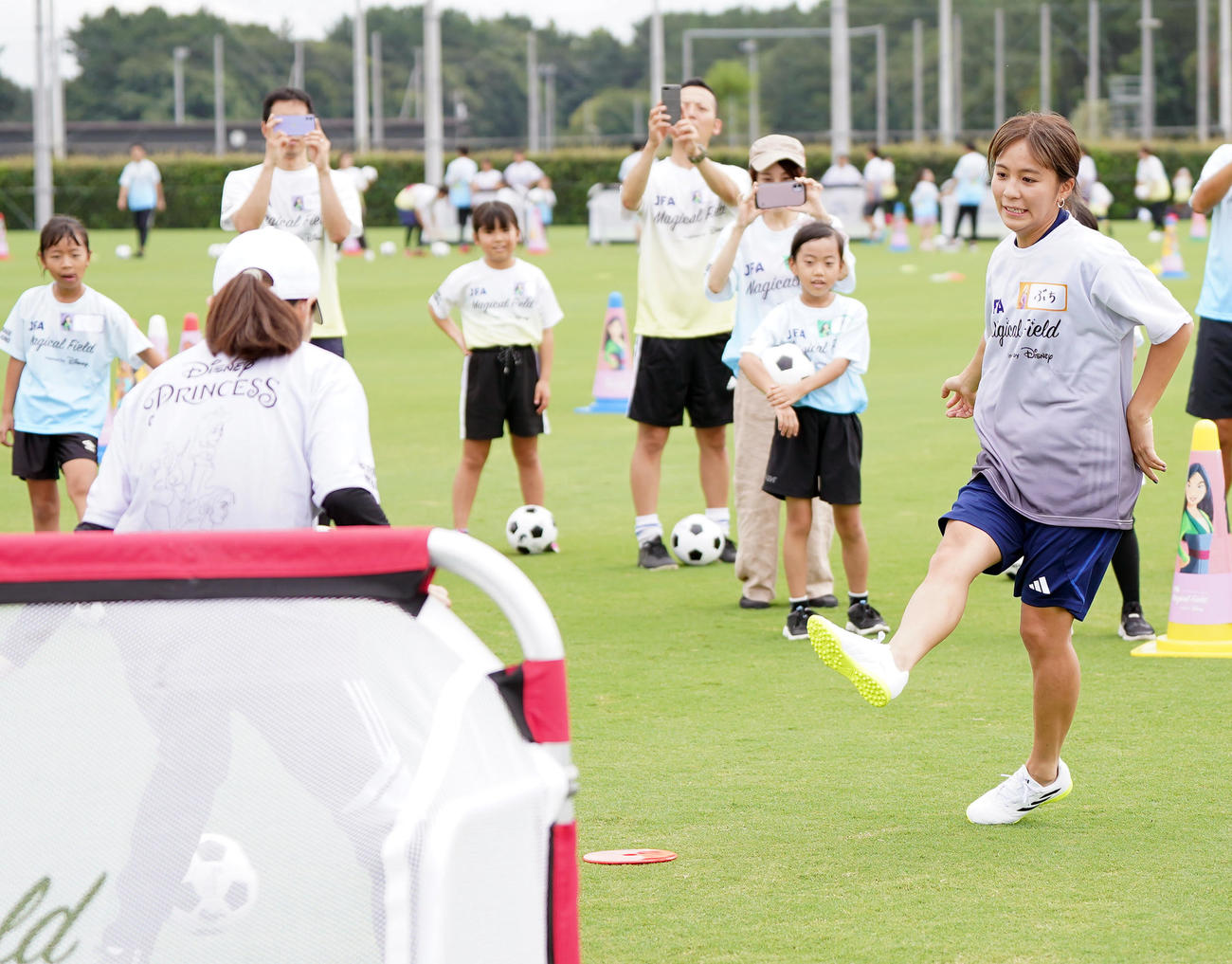 ファミリーサッカーフェスティバルでキーパーを務める澤さん（手前）からシュートを決める岩渕さん（撮影・狩俣裕三）