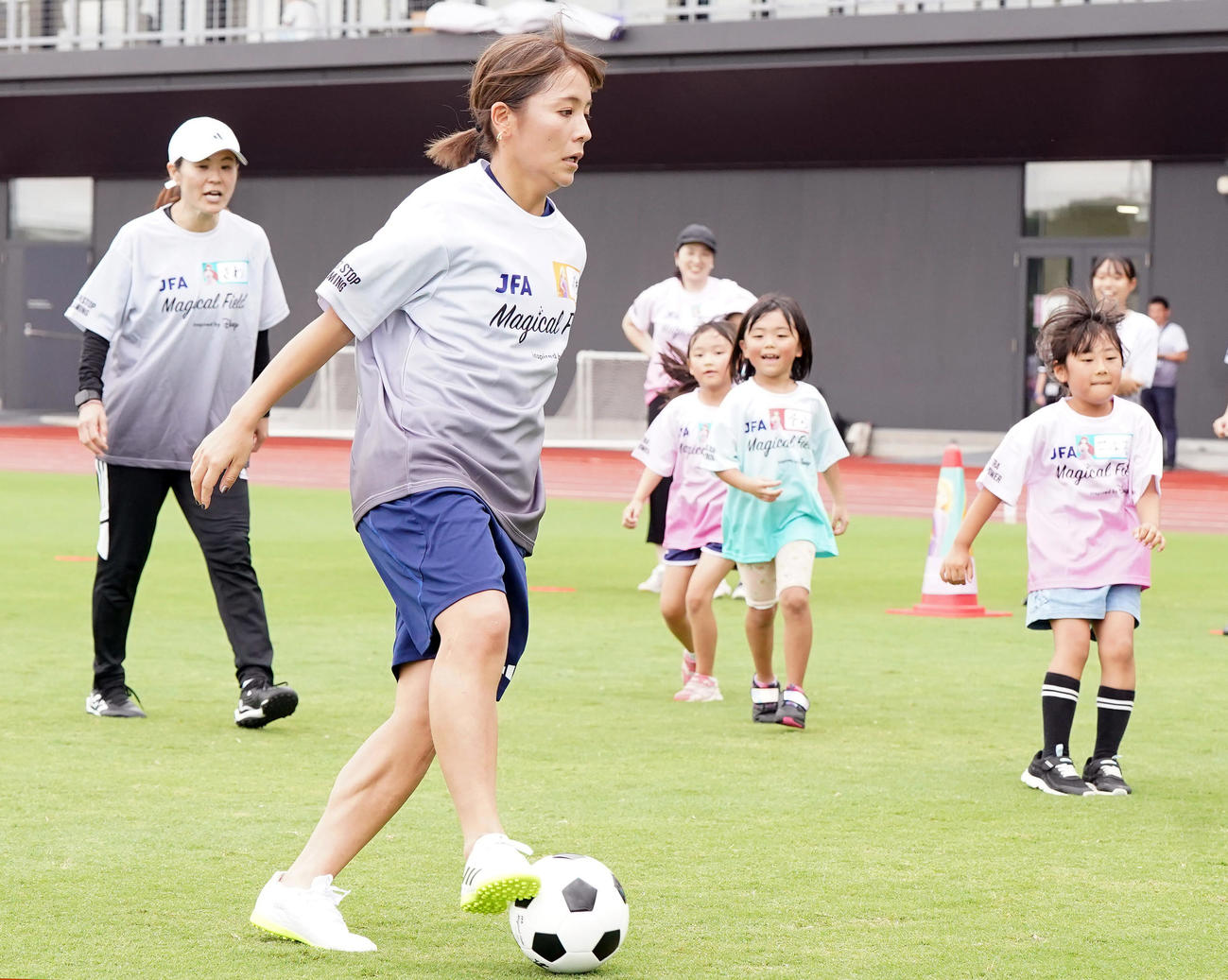 ファミリーサッカーフェスティバルで子どもたちといっしょにミニゲームをする岩渕さん（手前）と澤さん（左）（撮影・狩俣裕三）