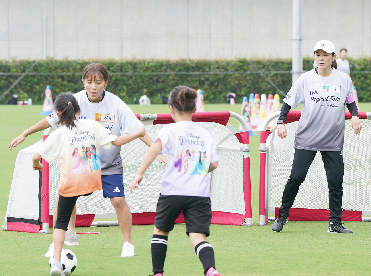 ファミリーサッカーフェスティバルで子どもたちといっしょにミニゲームをする岩渕さん（左）と澤さん（撮影・狩俣裕三）