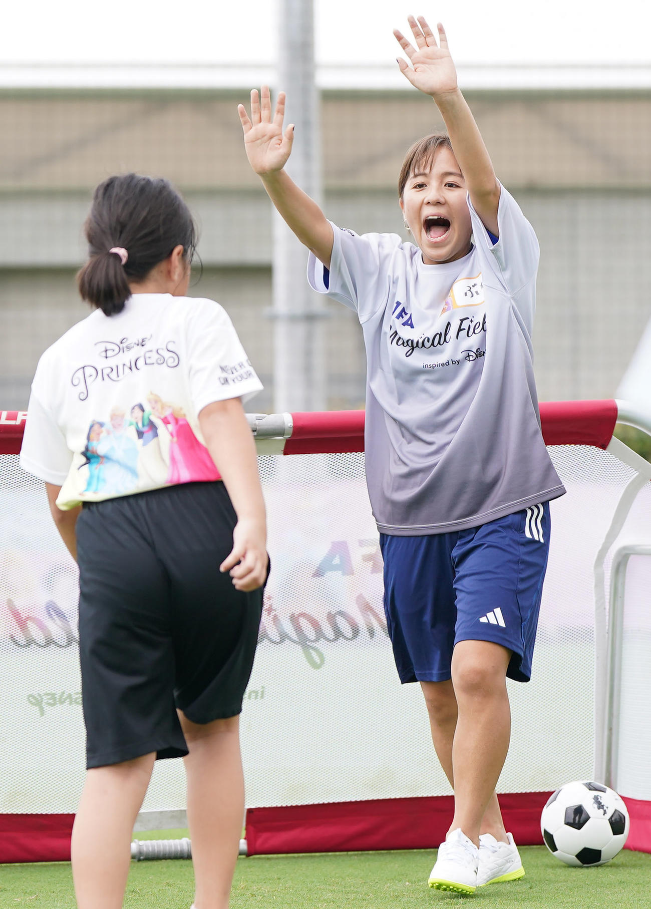 ファミリーサッカーフェスティバルで子どもとハイタッチをする岩渕さん（撮影・狩俣裕三）