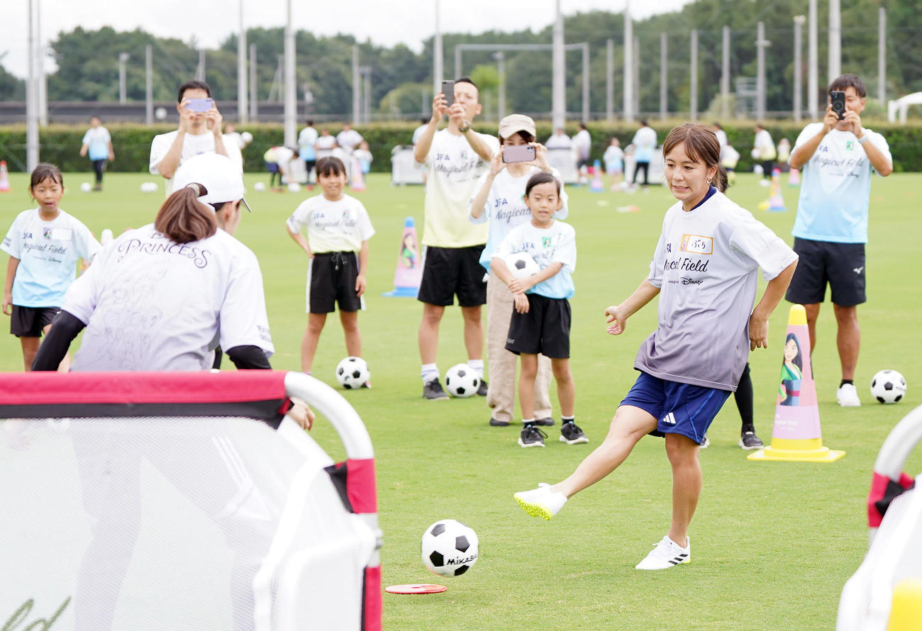 ファミリーサッカーフェスティバルでキーパーを務める澤さん（手前）からシュートを決める岩渕さん（撮影・狩俣裕三）