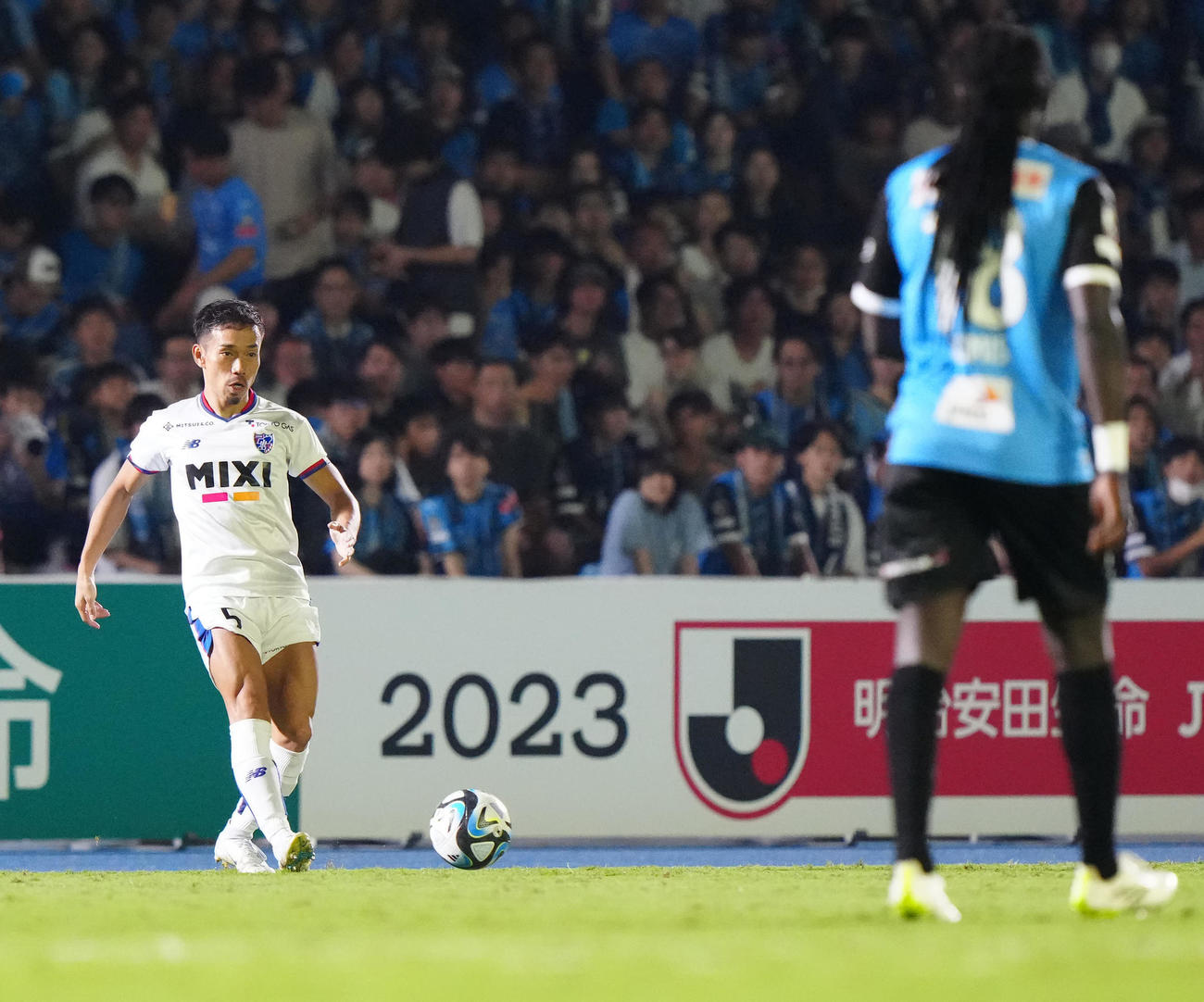 川崎F対東京　後半、パスを出す東京長友。右は川崎Fゴミス（撮影・江口和貴）