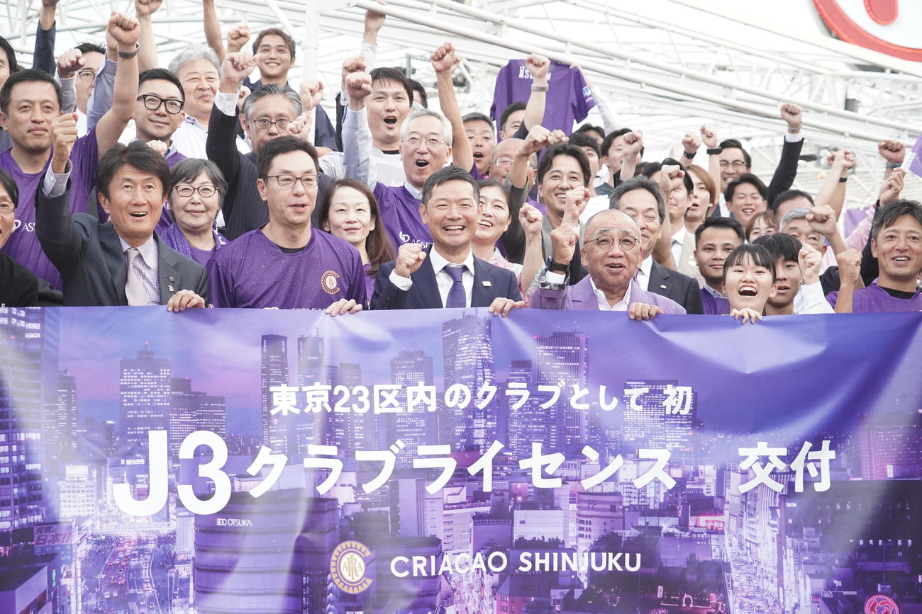 Jリーグクラブライセンスの交付を受けてガッツポーズをするクリアソン新宿の丸山和大代表（前列中央）ら関係者（撮影・佐藤成）