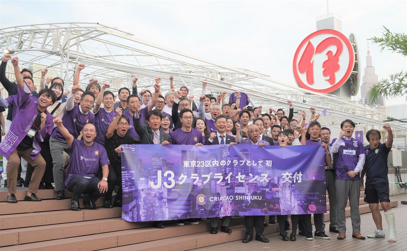 Jリーグクラブライセンスの交付を受けてガッツポーズをするクリアソン新宿の丸山和大代表（前列中央）ら関係者（撮影・佐藤成）