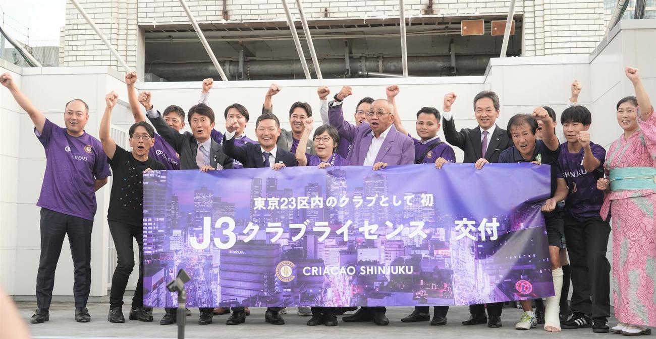 Jリーグクラブライセンスの交付を受けてガッツポーズをするクリアソン新宿の丸山和大代表（前列左から4人目）ら関係者（撮影・佐藤成）