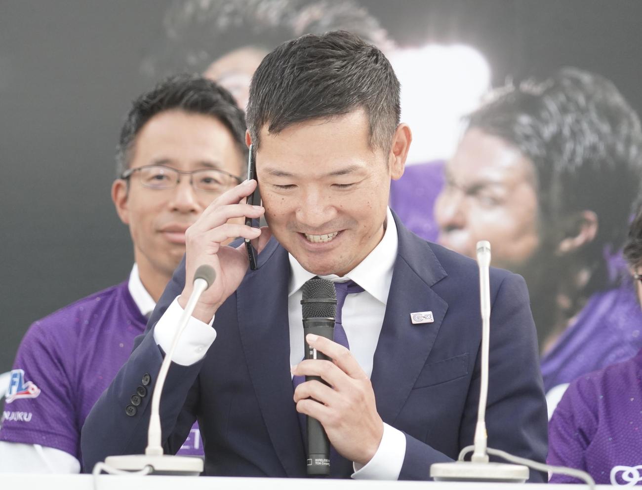 Jリーグクラブライセンスの交付の電話を受けるクリアソン新宿の丸山和大代表（撮影・佐藤成）