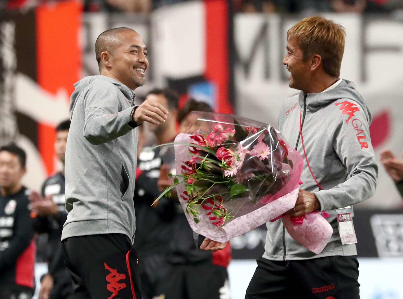 2018年12月1日、試合後、稲本（右）に花束を渡し笑顔の小野