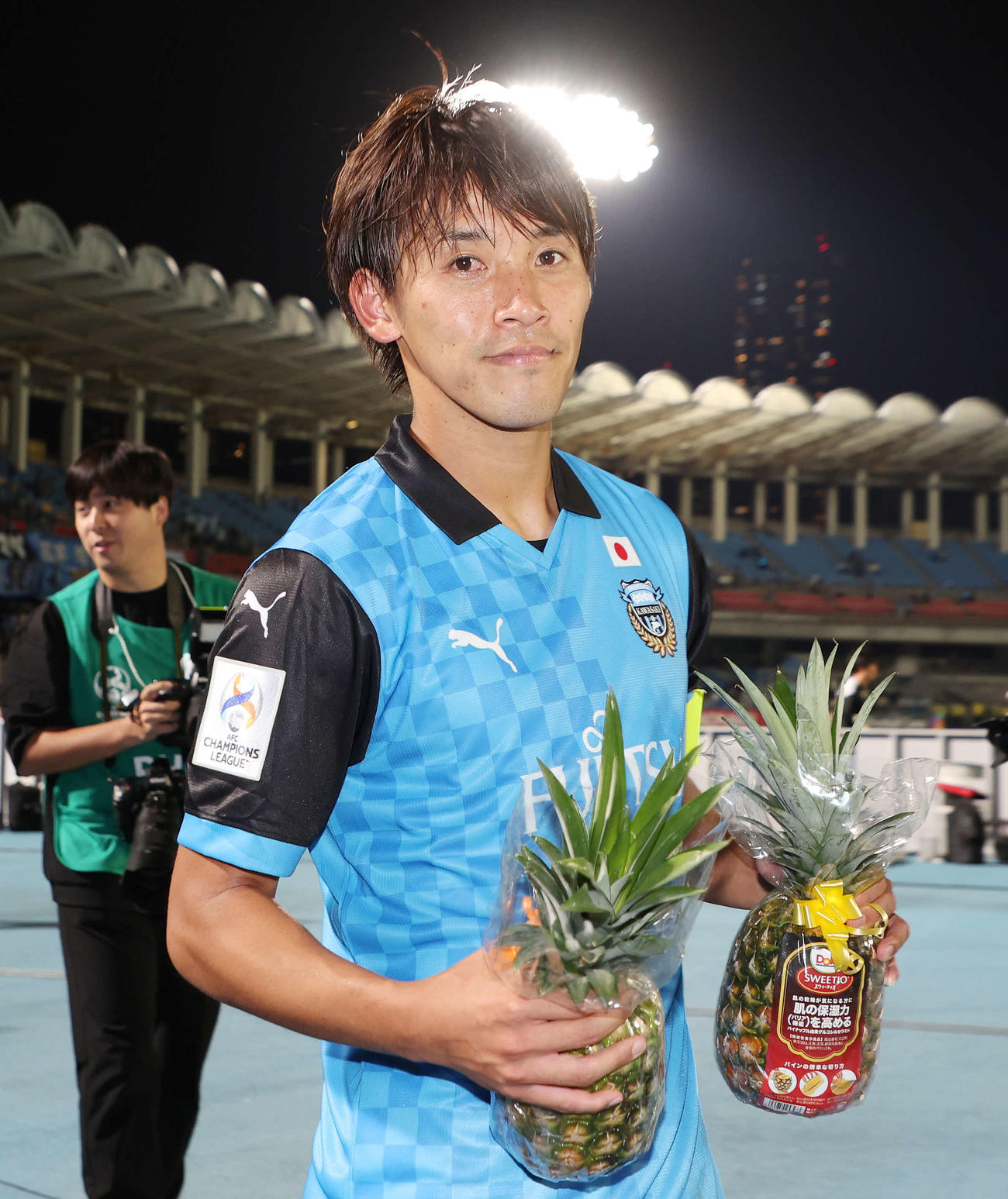 川崎F対蔚山　決勝ゴールを決めた川崎F橘田はサポーターからのパイナップルを手に笑顔を見せる（撮影・宮地輝）
