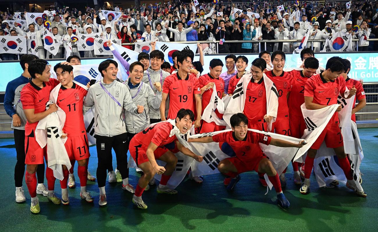 7日、アジア大会男子サッカー決勝で日本を下し、ファンと一緒に喜ぶ韓国代表の選手たち（ロイター）
