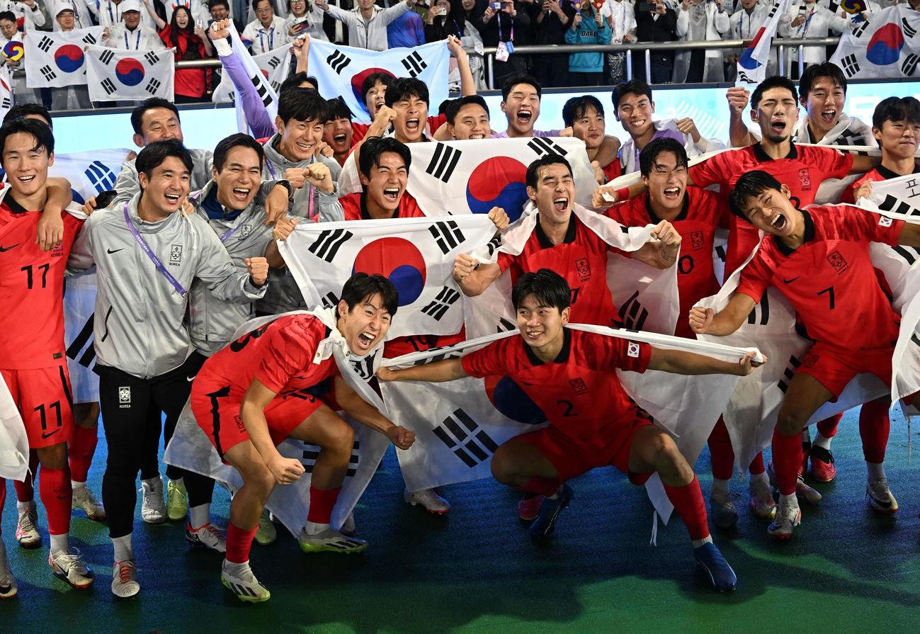 7日、アジア大会男子サッカー決勝で日本を下し、ファンと一緒に喜ぶ韓国代表の選手たち（ロイター）