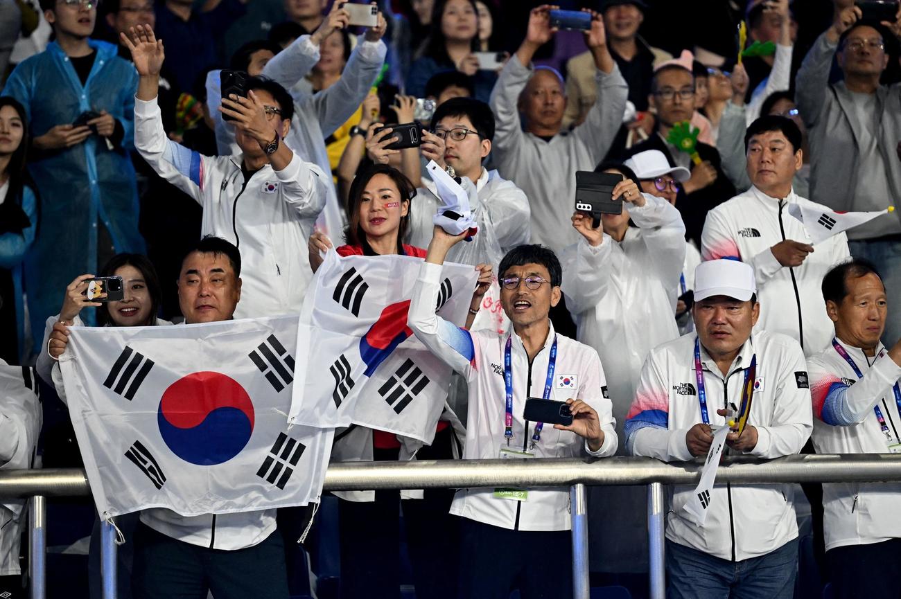 7日、アジア大会男子サッカー決勝で優勝し、太極旗を広げて喜ぶファン（ロイター）