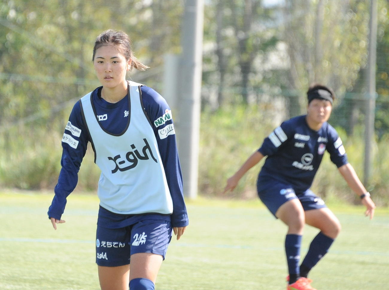 試合形式の練習でボールを追う石田（左）