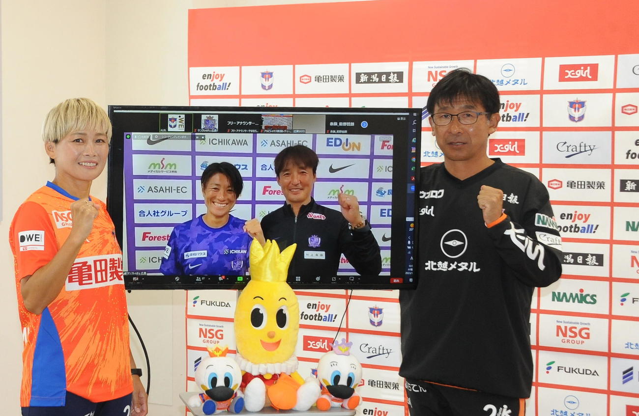 WEリーグカップ決勝直前オンライン合同会見で、広島の近賀と中村監督が映るモニターを挟み、ガッツポーズの新潟・川澄（左）と橋川監督