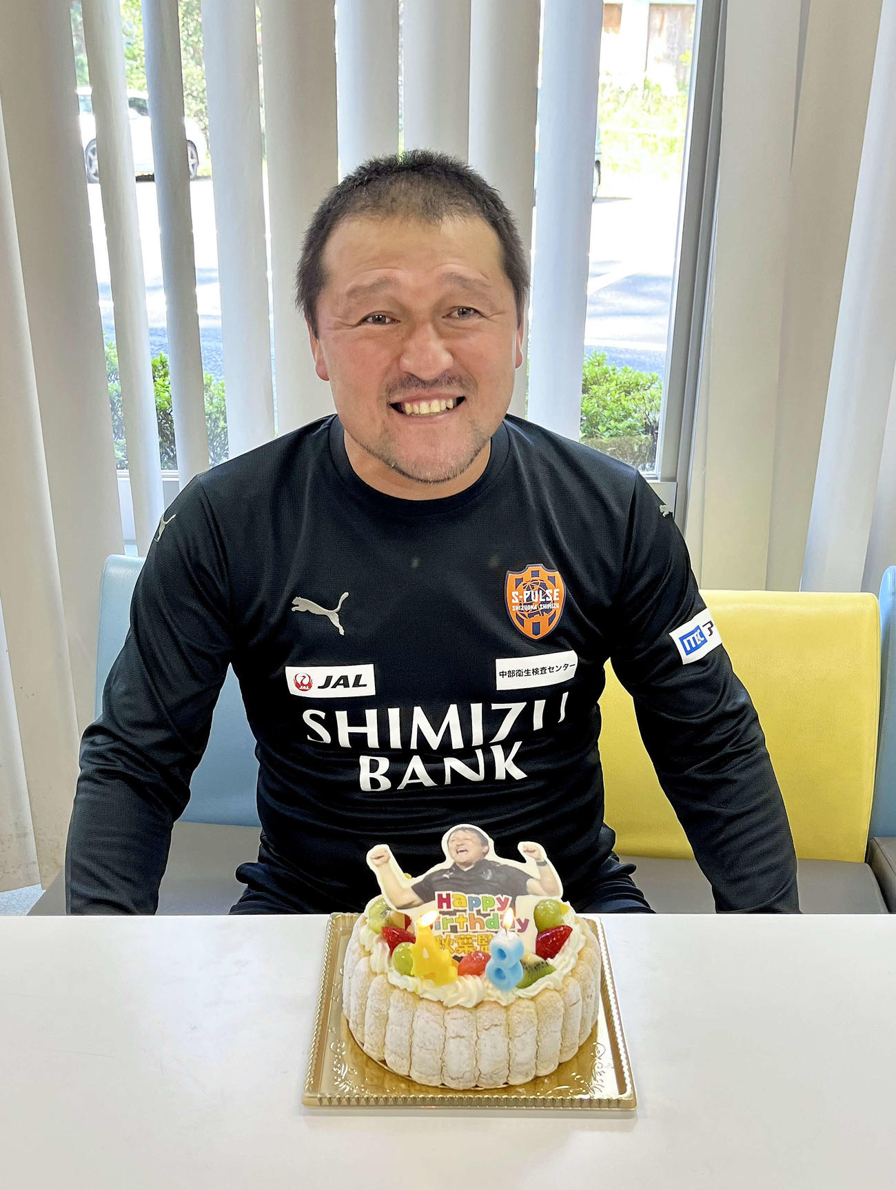 報道陣からのケーキを受け取り、笑顔を見せる清水の秋葉忠宏監督
