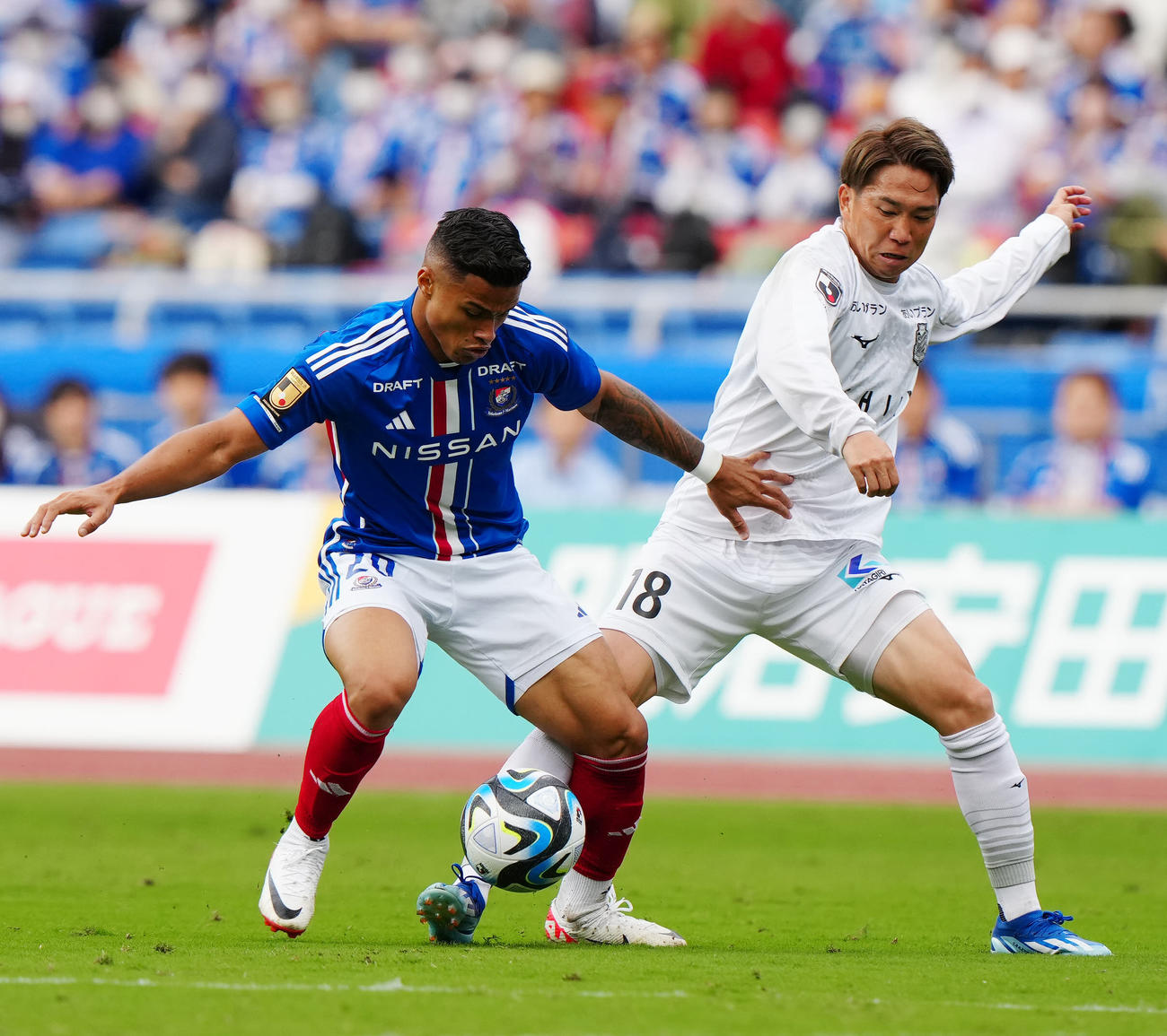 横浜対札幌　前半、競り合う横浜マテウス（左）と札幌浅野（撮影・江口和貴）