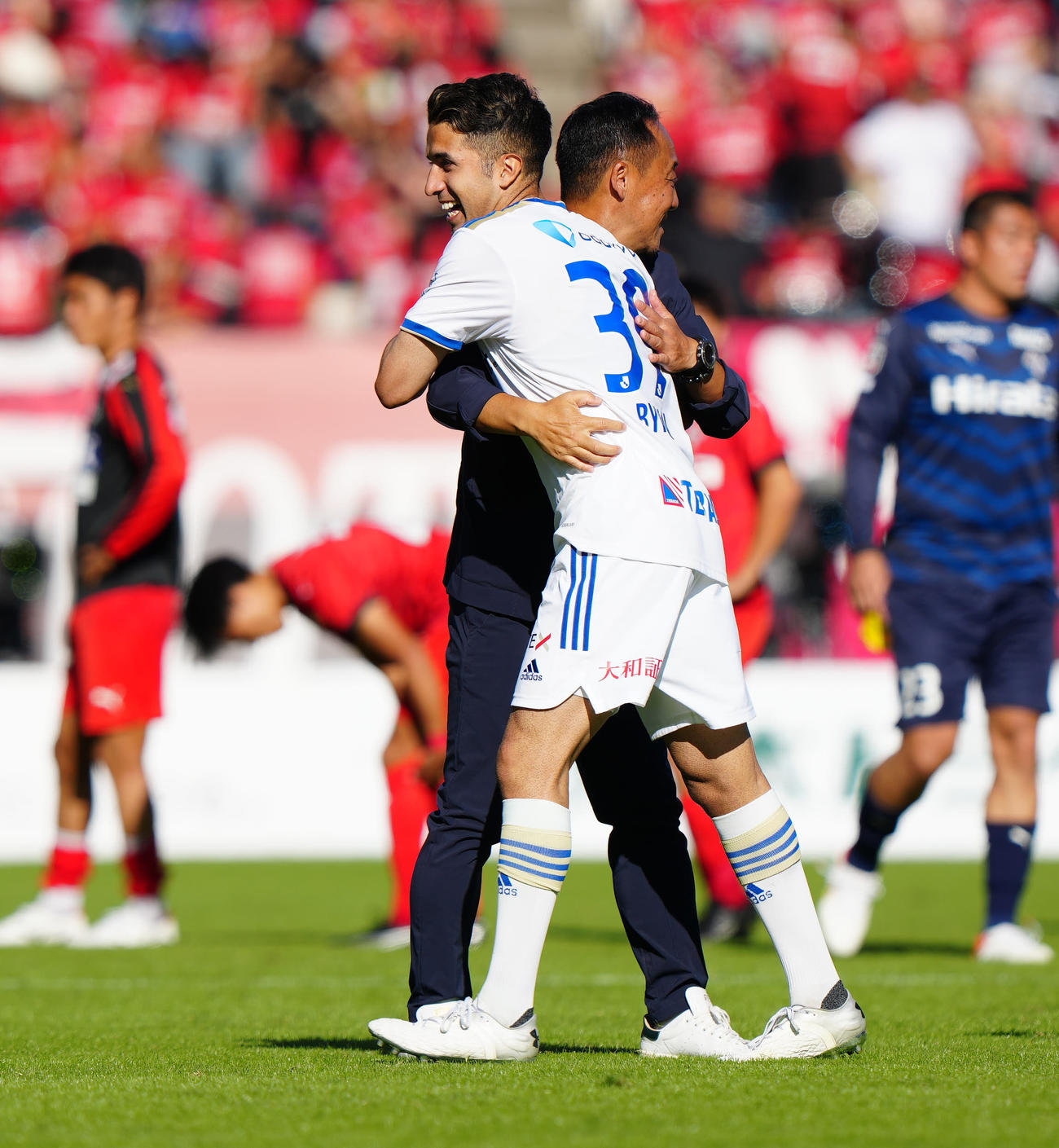 熊本対町田　J1昇格を決め、町田黒田監督（後方）と抱き合うバスケス（撮影・江口和貴）