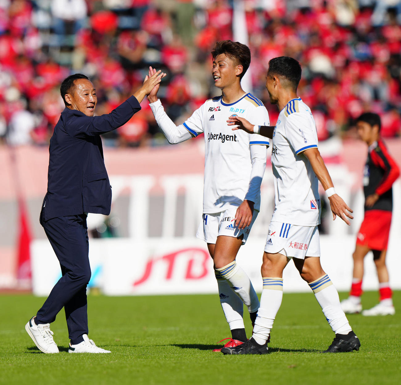 熊本対町田　J1昇格を決め、町田藤原（中央）とタッチを交わす黒田監督（撮影・江口和貴）