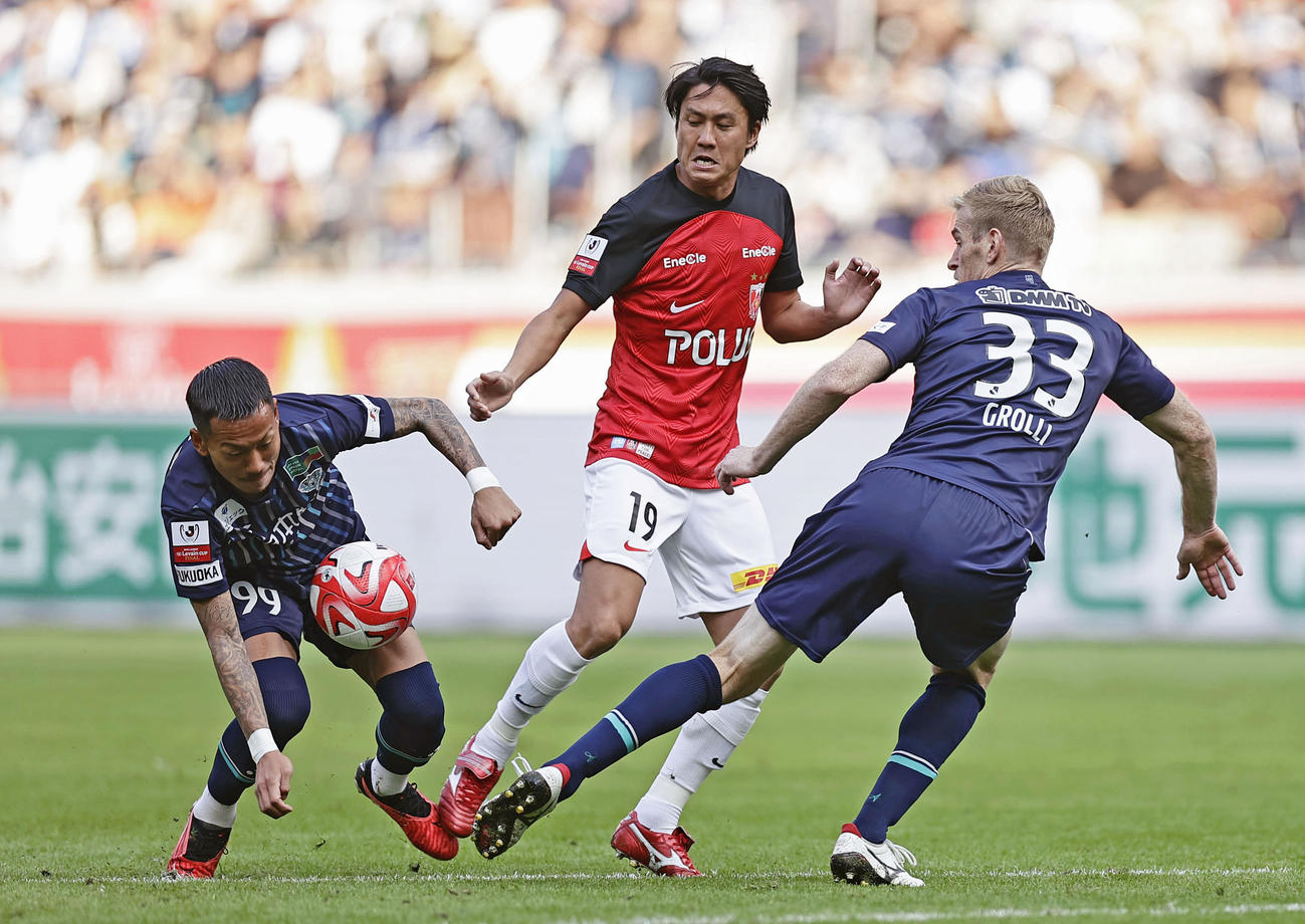福岡―浦和　後半、浦和・岩尾と競り合う福岡・井手口（左）とドウグラス・グローリ（共同）
