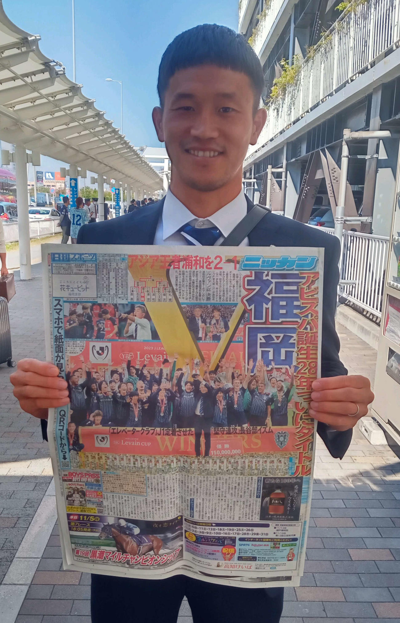 ルヴァン杯優勝を伝える本紙1面を手に喜ぶ主将のDF奈良竜樹（撮影・菊川光一）