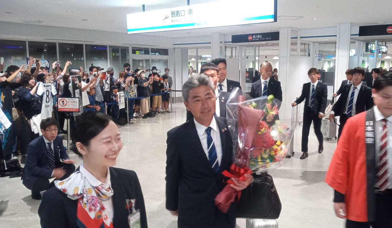 福岡空港では大勢のファンが長谷部茂利監督（中央）らを出迎えた（撮影・菊川光一）