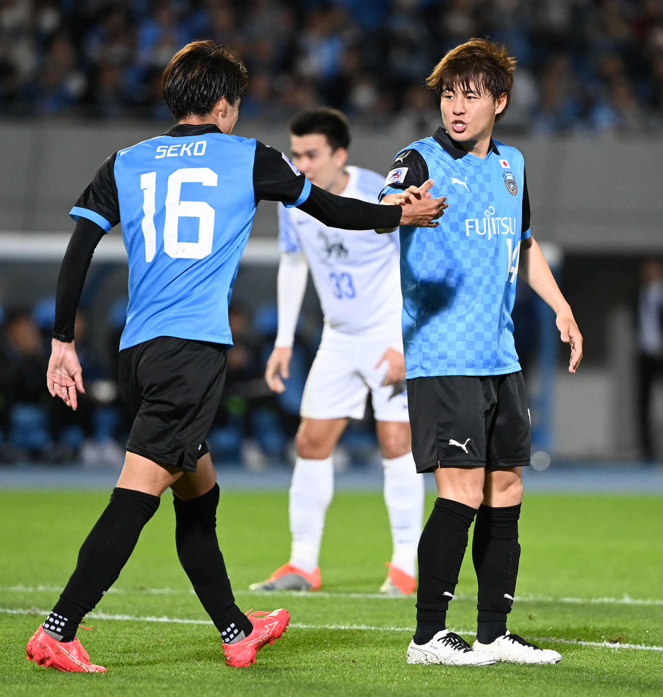 川崎F対BGパトゥム　前半、PKを決めて追加点を奪った川崎F脇坂（右）は瀬古とタッチを交わす（撮影・山崎安昭）