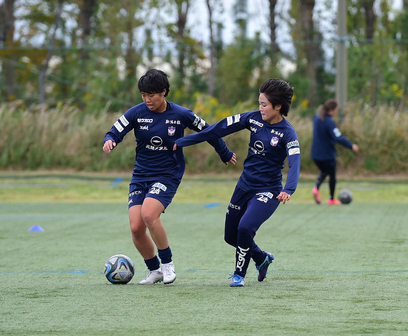 競り合う新潟レディース三浦（右）