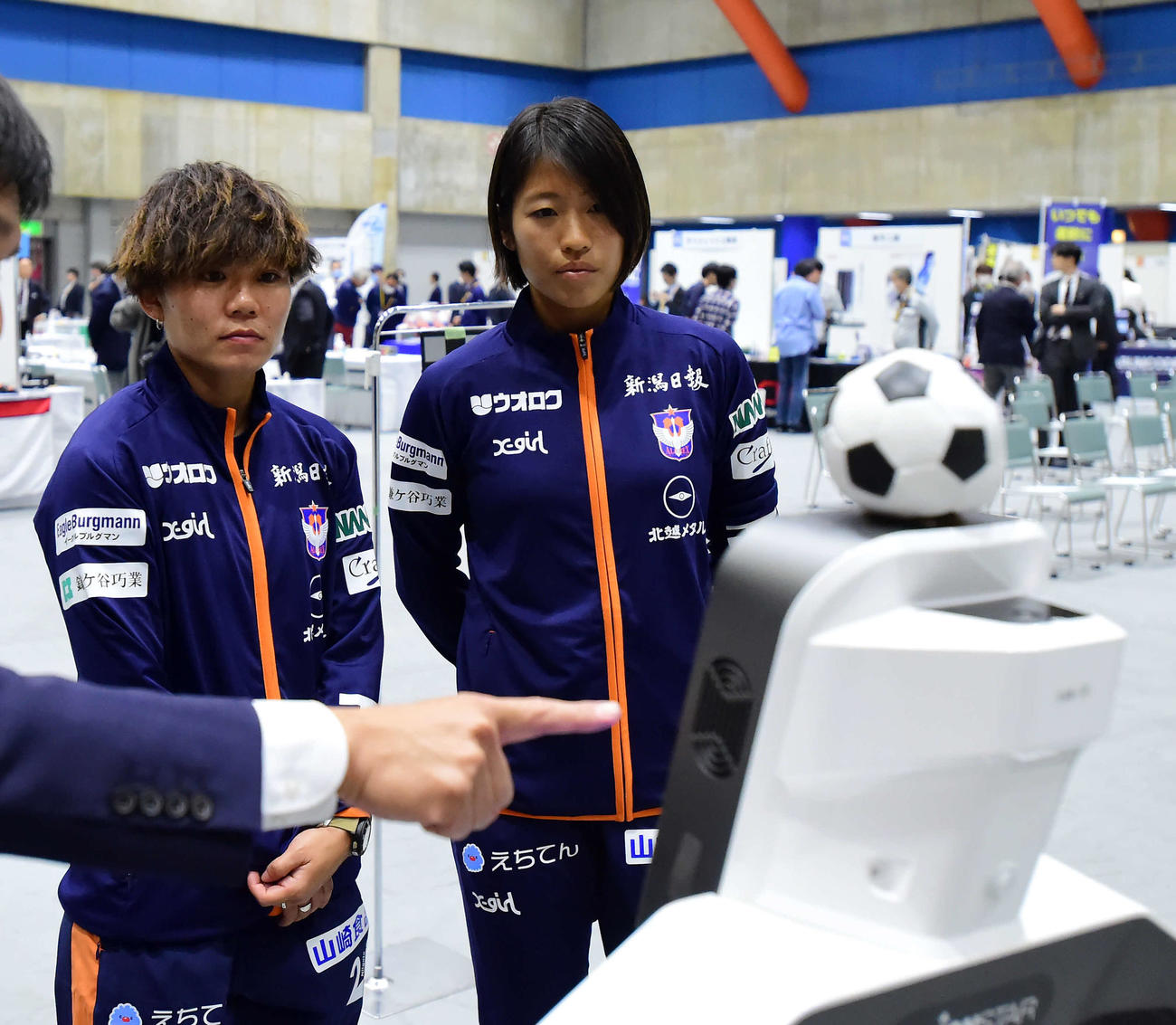 ロボットの説明を真剣に聞く新潟レディースの杉田（左）と石淵
