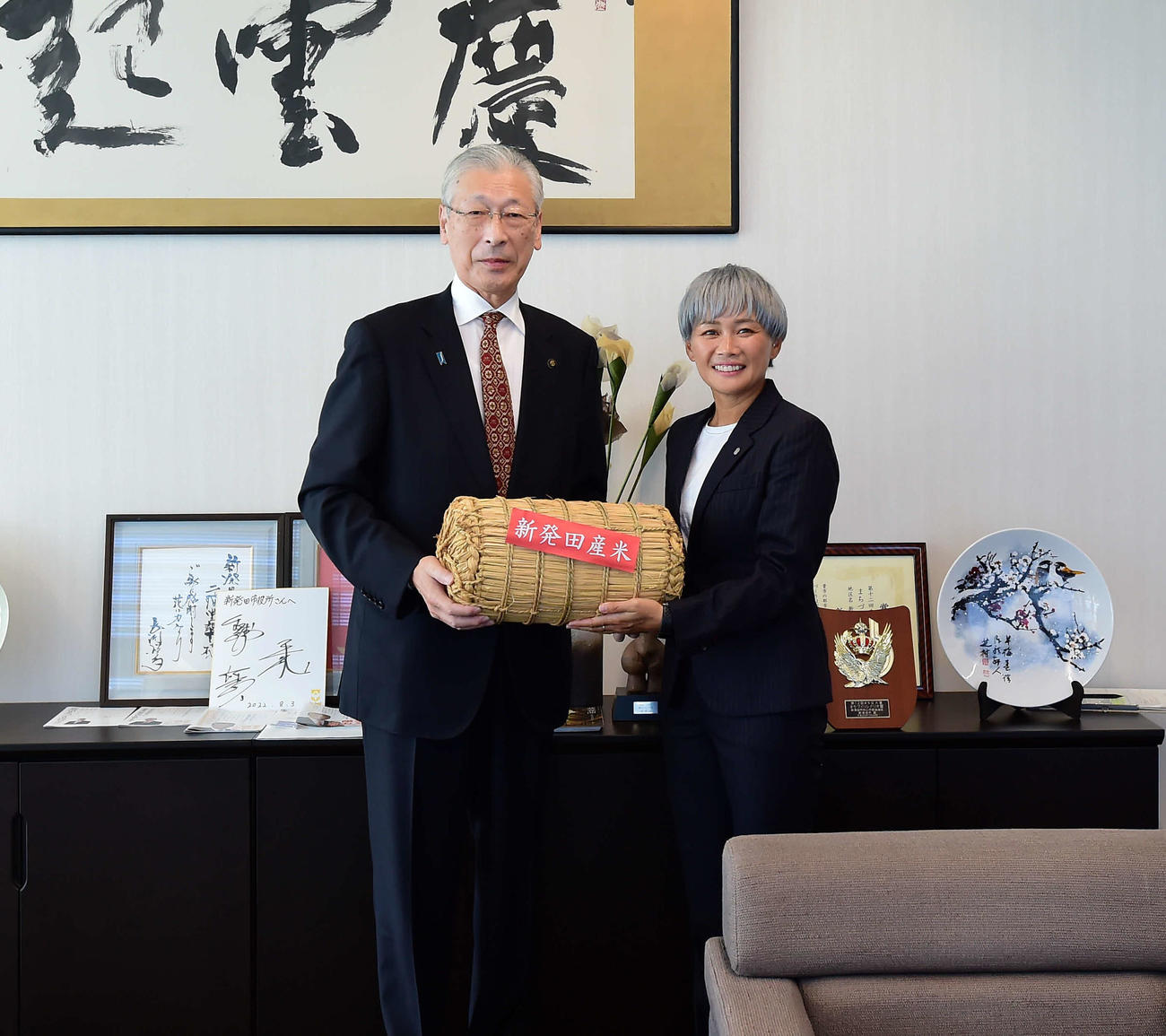二階堂市長（左）から新発田市のお米を受け取る新潟レディース川澄