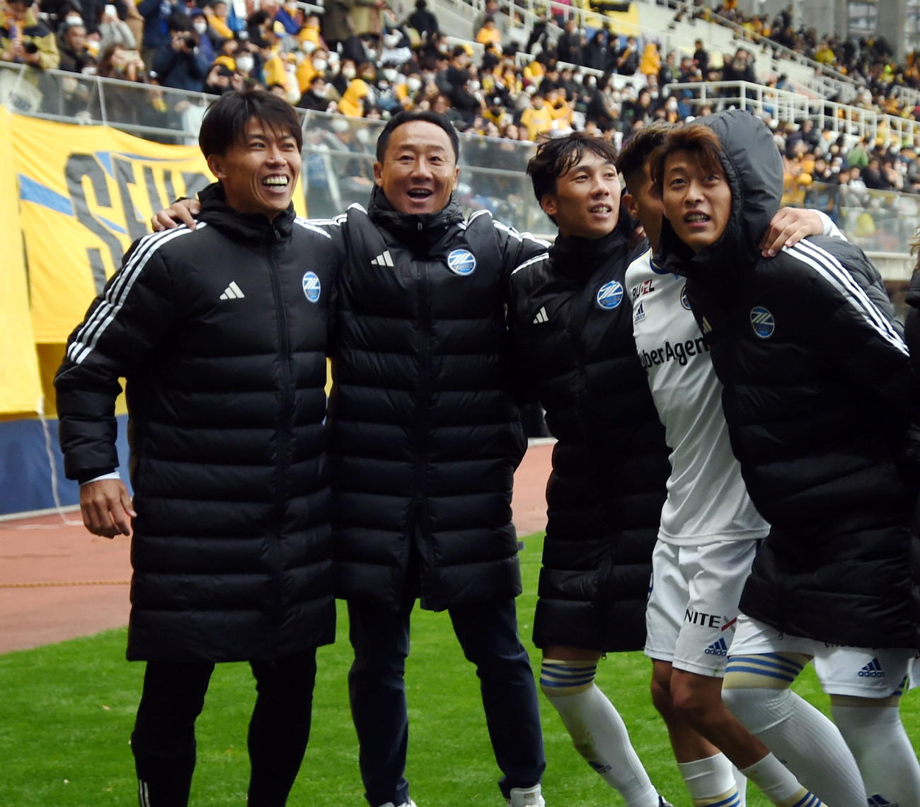 仙台対町田　最終戦を勝利で飾り肩を組んでサポーターと喜びを分かち合う町田黒田監督（左から2人目）ら（撮影・山田愛斗）