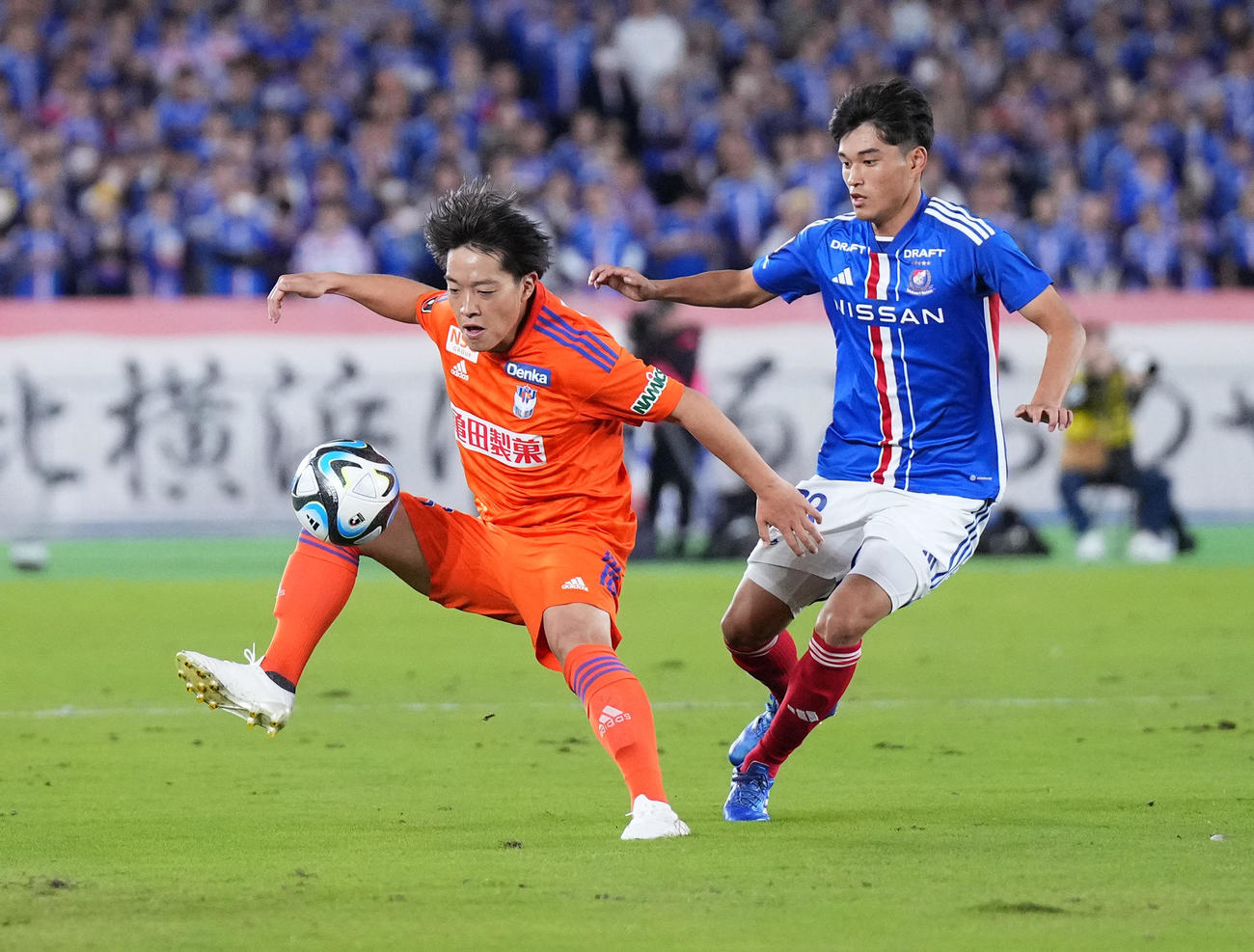 横浜対新潟　前半、横浜山根（右）と競り合う新潟高木（撮影・菅敏）