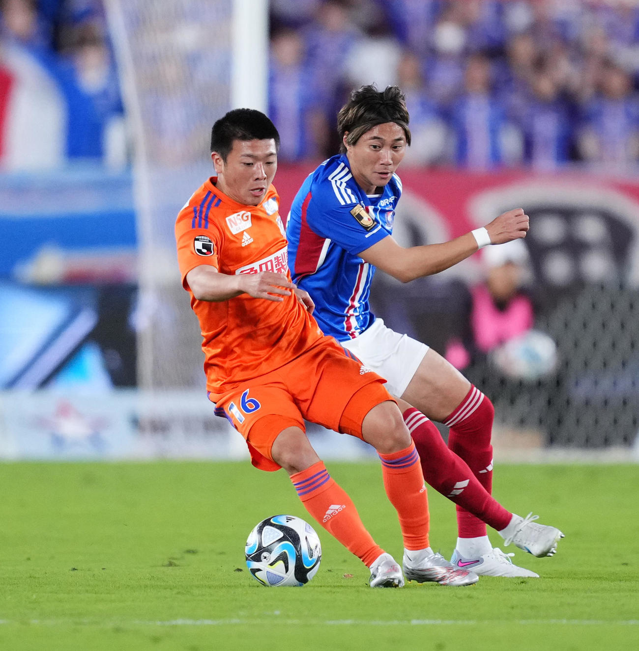 横浜対新潟　前半、競り合う新潟小見（左）（撮影・菅敏）