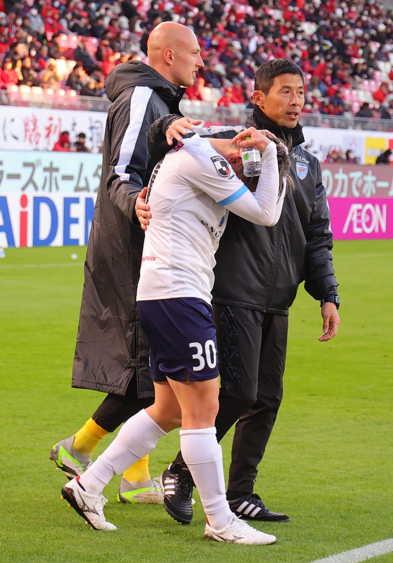 鹿島対横浜FC J2降格が決まり涙する横浜FC山根（手前）をなぐさめる四方田監督（撮影・野上伸悟）