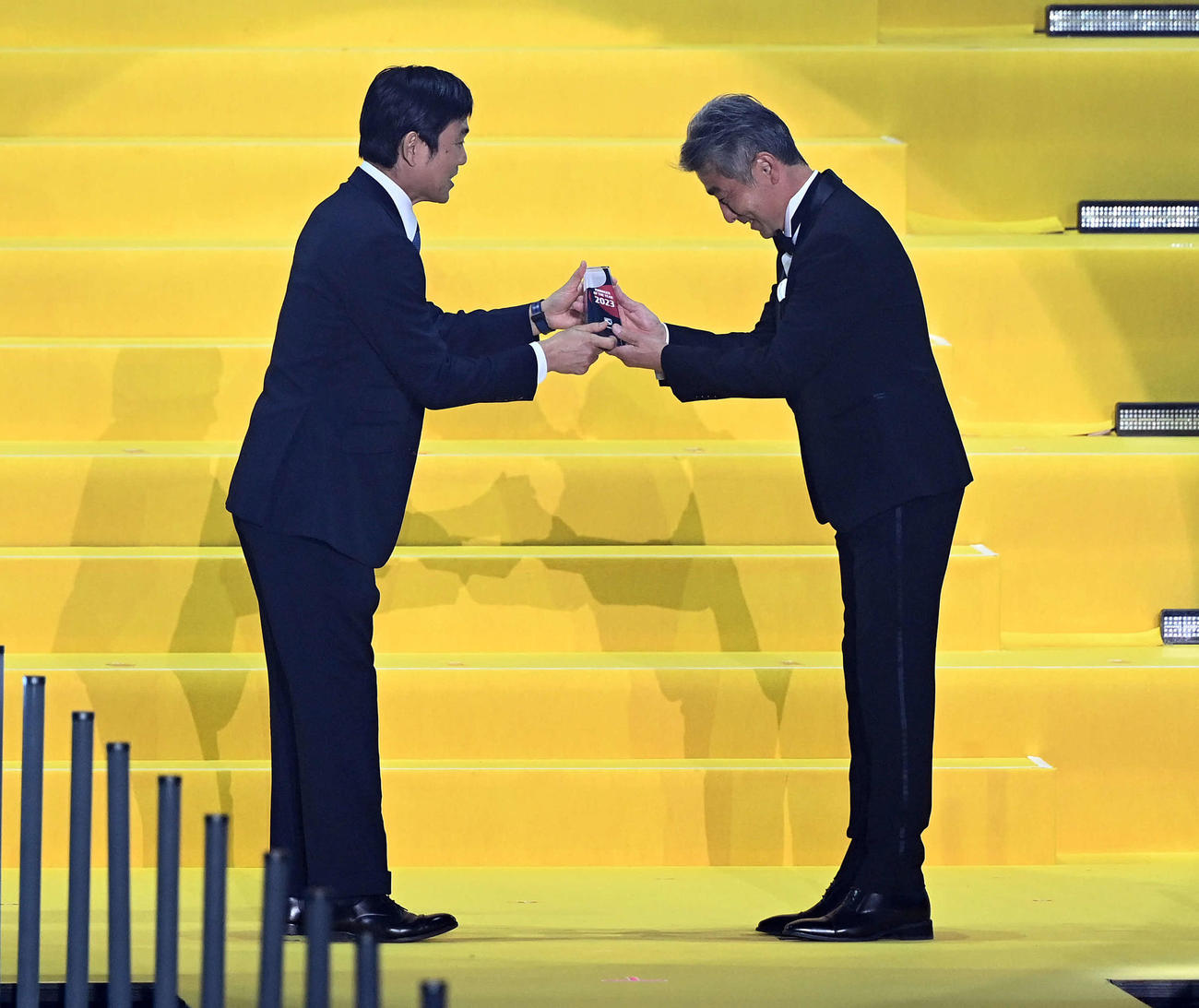 優秀監督賞を受賞し森保一日本代表監督（左）からトロフィーを受け取る福岡長谷部茂利監督（撮影・たえ見朱実）
