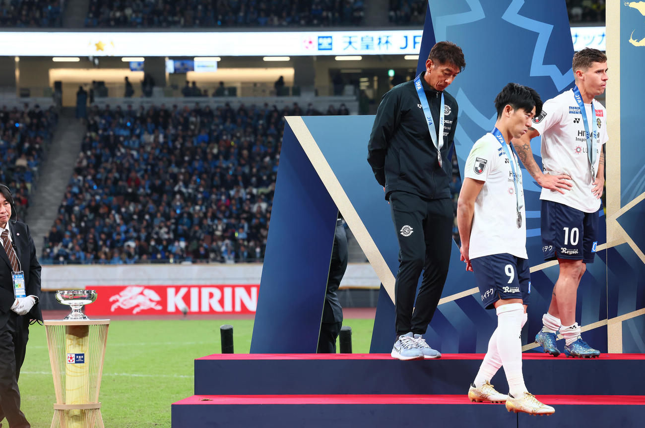 川崎F対柏　準優勝の表彰式を終え、天皇杯を背に引き揚げる柏井原監督（左）ら（撮影・足立雅史）