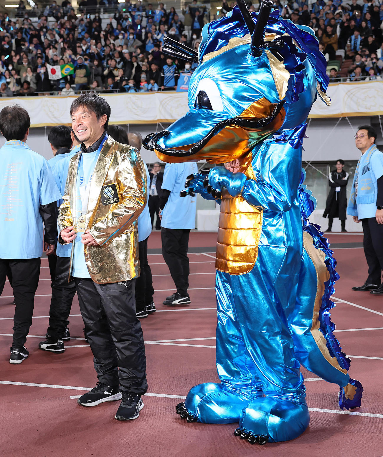 川崎F対柏　天皇杯を制し、特製の金ジャケットに袖を通し笑顔を見せる川崎F鬼木監督。右はふろん太（撮影・足立雅史）