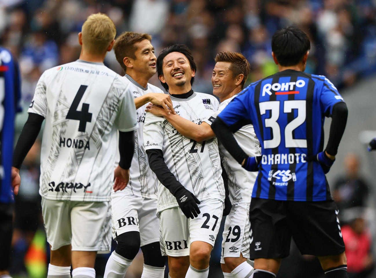 「橋本英郎引退試合」G大阪05対日本代表フレンズ　前半、先制ゴールを決めた日本代表フレンズ橋本英郎氏（中央）を祝福するイレブンら（撮影・上山淳一）