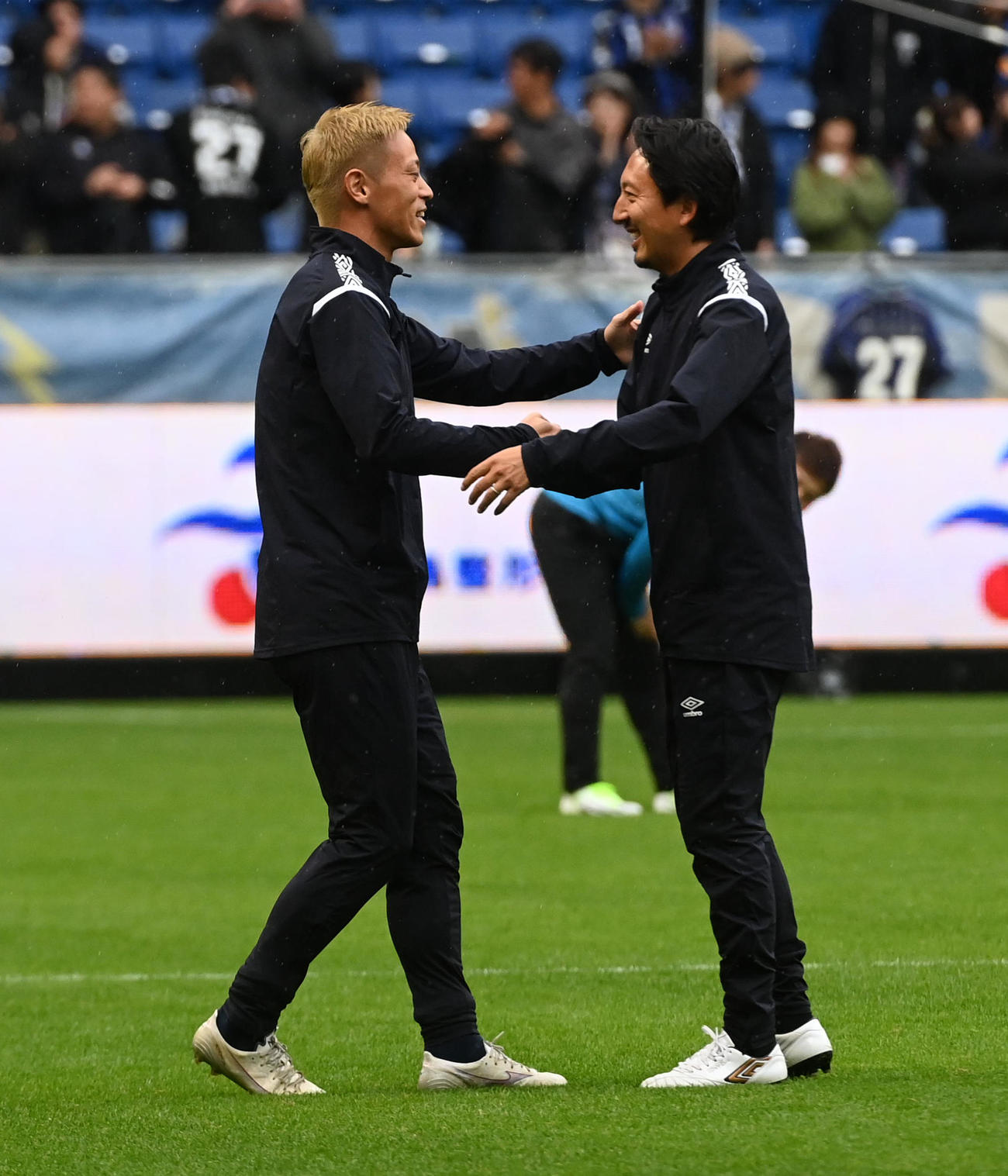 ガンバ大阪’05対日本代表フレンズ　試合前の練習で握手をする本田圭佑（左）と橋本英郎（撮影・前岡正明）