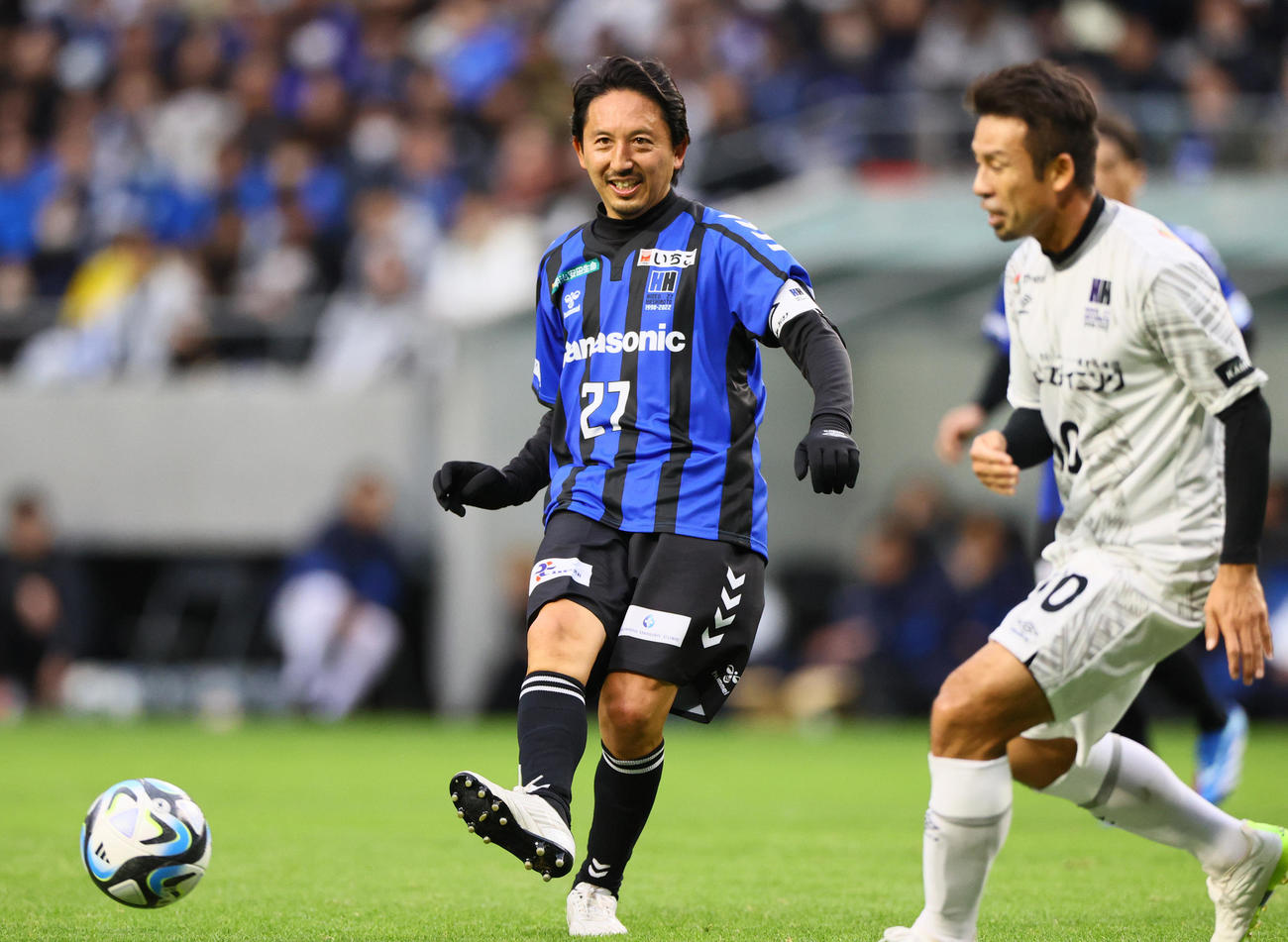 「橋本英郎引退試合」G大阪05対日本代表フレンズ　後半、G大阪05橋本英郎は笑顔でパスを送る。右は日本代表フレンズ山瀬功治（撮影・上山淳一）