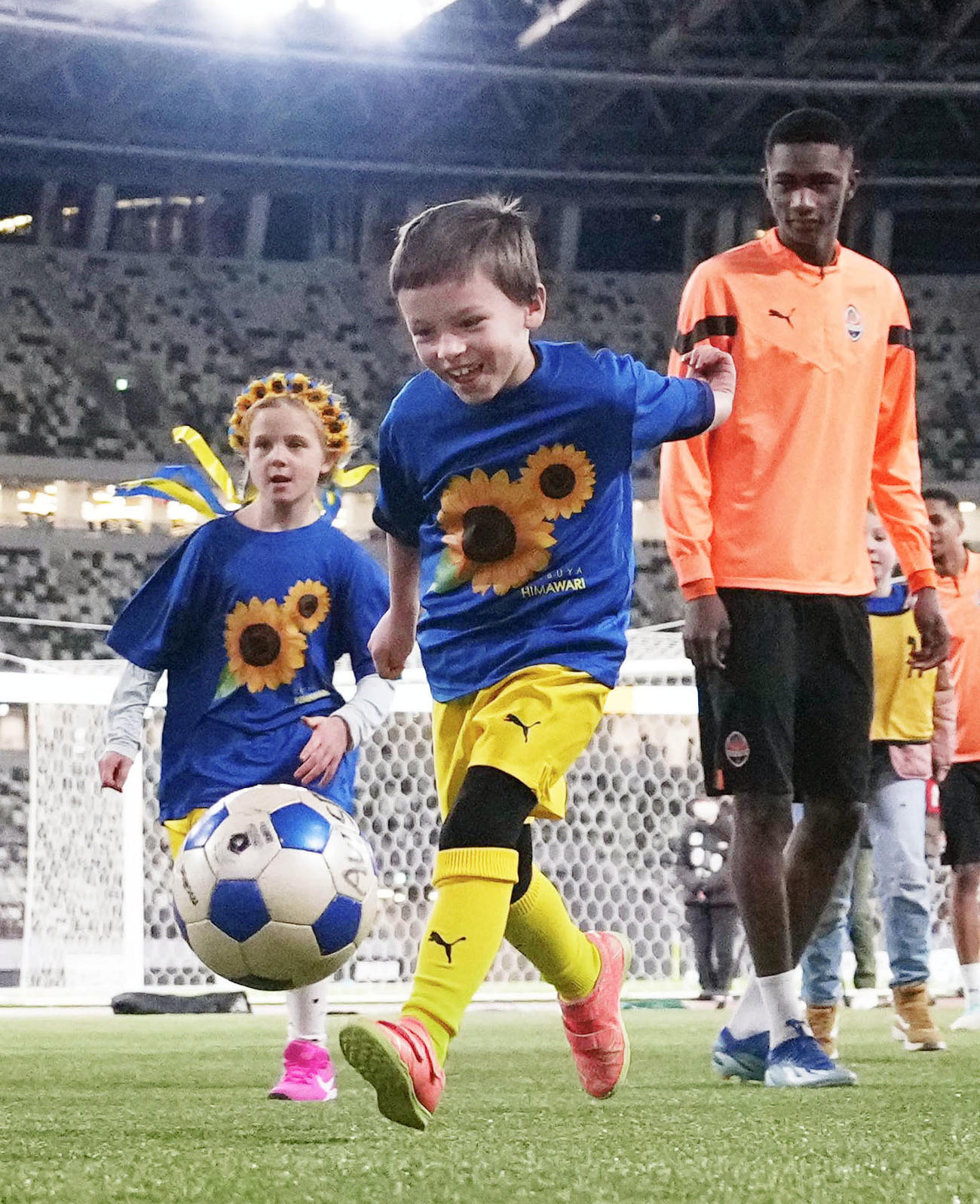 ウクライナ復興支援の慈善試合前、選手らによるサッカー教室に参加した同国の子どもたち（共同）